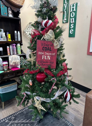A playful tree with red and silver ribbon and a hand-painted sign
